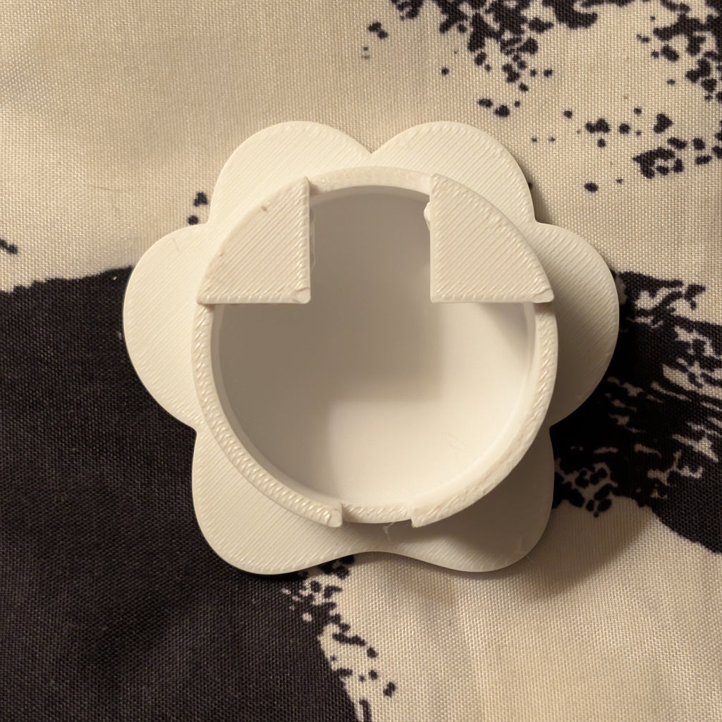 White paw-shaped object on a patterned fabric background