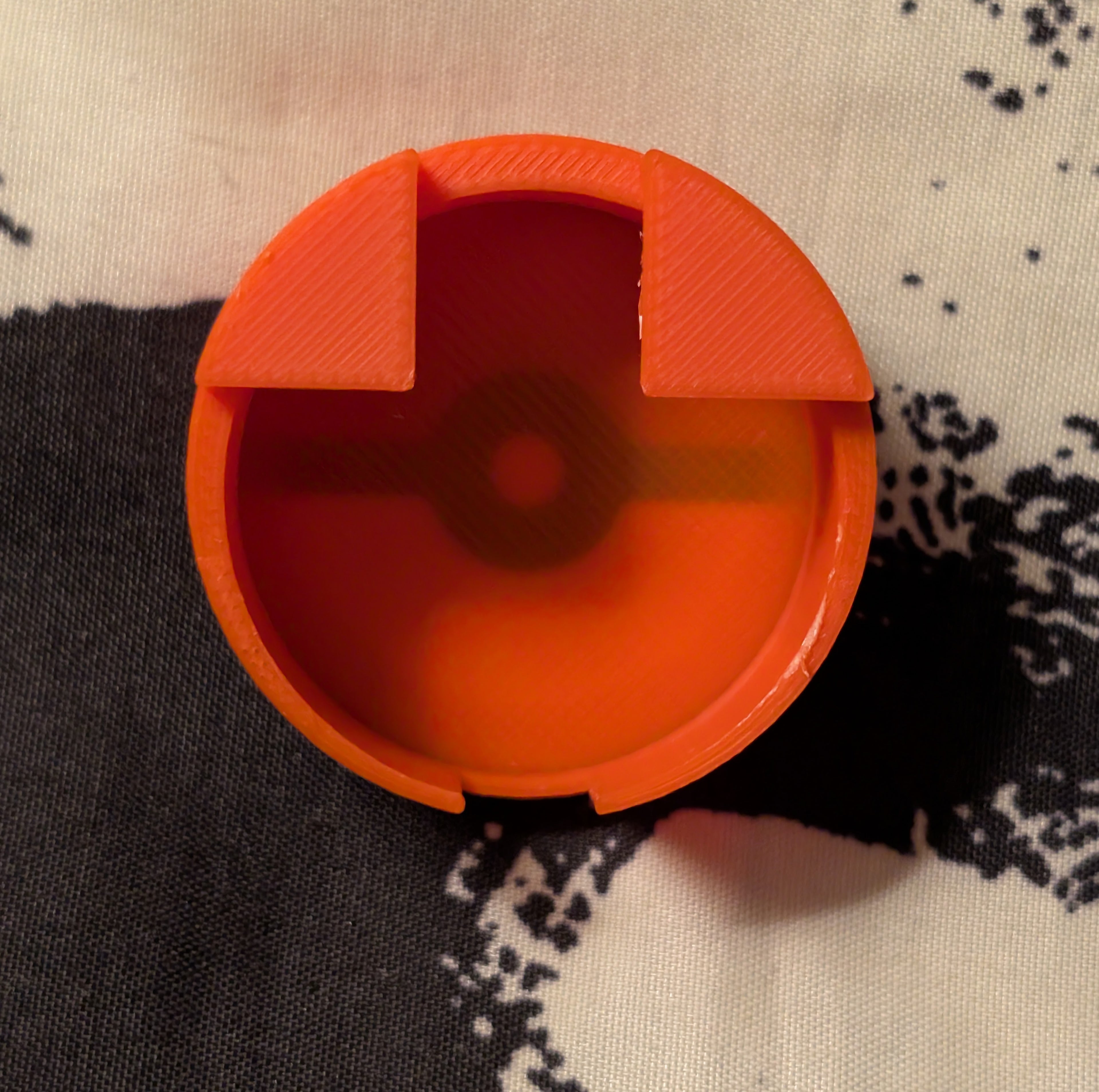 Red plastic component on a patterned fabric background