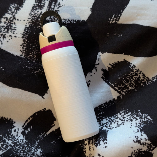White cylindrical object with a pink band on a black and white patterned surface